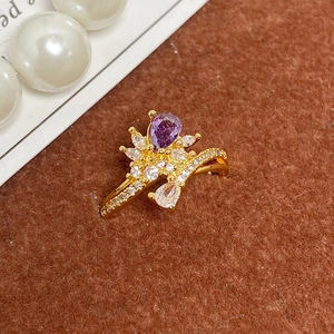 Vue macro détaillée d'une bague couronne dorée ornée d'un zircon violet en forme de goutte