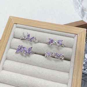 Macro shot of silver butterfly rings set with purple cubic zirconia stones on velvet