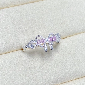 Macro detail of silver butterfly ring featuring pink zircon stones and twisted band
