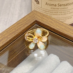Macro view of gold flower ring featuring iridescent petals and central cubic zirconia