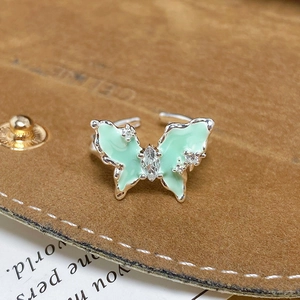 Détail macro d'une bague papillon en émail vert menthe ornée de zircons brillants