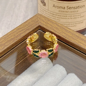 Close-up of vintage floral open ring with pink enamel flowers and green leaves