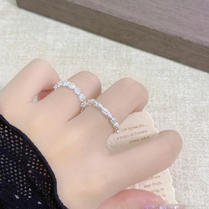 Detailed view of silver flower and rope knot rings worn together in an aesthetic setting
