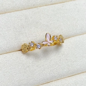 Macro view of gold-plated ring with pink enamel butterfly and purple cubic zirconia