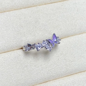 Macro shot of silver butterfly ring featuring purple enamel wings and cubic zirconia gems
