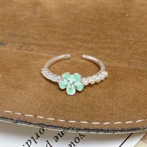 Détail de la bague réglable avec fleur en émail vert menthe, perles et oxydes de zircon