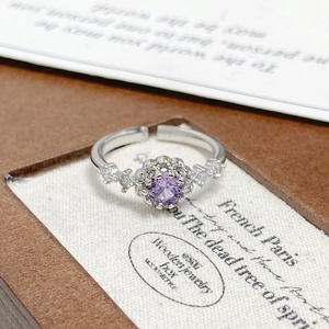 Macro shot of a floral silver ring with a purple zircon stone on a jewelry display tray