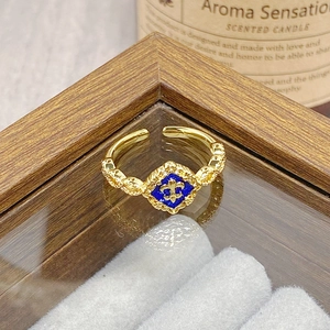 Detail of vintage gold open ring with blue enamel and fleur-de-lis floral pattern