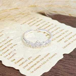 Macro view of adjustable silver ring with cluster zircon accents on artistic background