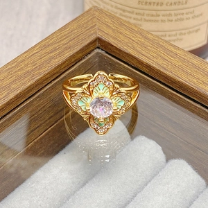 Macro shot of vintage gold flower ring with green enamel, zircon center and open band