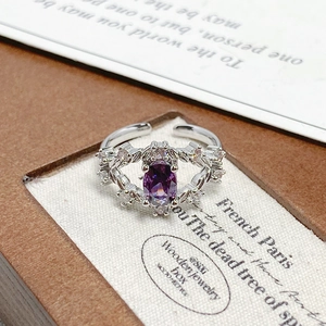 Macro detail of silver adjustable ring with oval purple gemstone and floral micro-pave