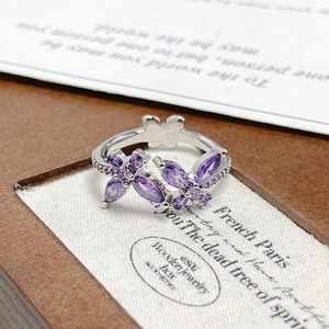 Macro shot of silver ring with purple zircon butterflies and sparkling details