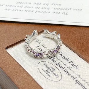 Macro detail of silver butterfly ring featuring sparkling purple zircon inlays