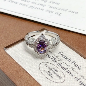 Macro shot of purple gemstone ring with sparkling zircon petals on silver band