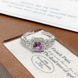 Macro shot of silver ring with purple zircon stone and pavé diamonds in a jewelry box