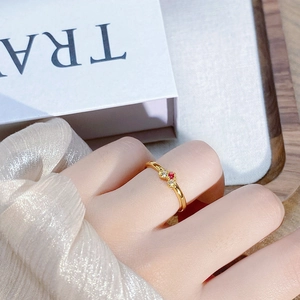 Nahaufnahme eines Vintage-Goldrings mit rotem Rubin und weißen Zirkonia an der Hand