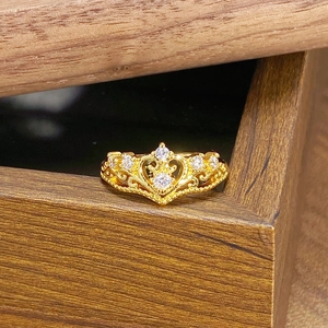 Makroaufnahme eines goldenen Vintage Kronenrings mit Zirkonia und Herz-Hohl-Detail