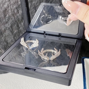 Detailansicht silberner Flügel- und Geweihringe mit Zirkon-Besatz in schwarzer Box