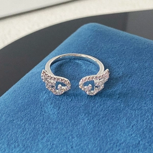 Makroaufnahme: Silberner Engelsflügel-Ring mit Zirkonia-Besatz auf blauem Hintergrund