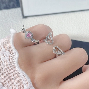 Detailansicht der silbernen Flügelringe mit rosa Herzstein und Zirkonia-Besatz