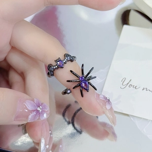 Macro shot of gothic bat and spider rings with purple gems and dark metal finish