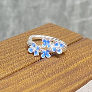 Detail of S925 silver ring with blue enamel flowers and tiny cubic zirconia inlay