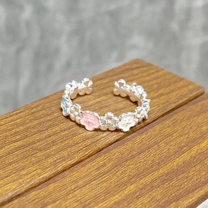 Detail of floral enamel open ring featuring pink and blue flowers on silver band