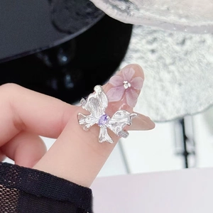 Detailed macro view of butterfly ring with purple zircon and frosted pink flower petal