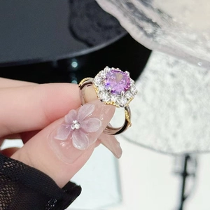 Macro shot of a floral purple gemstone ring with white diamonds and two-tone twisted band