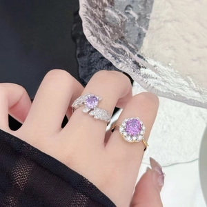 Detail view of purple zircon rings with silver wings and floral petal halo diamond settings