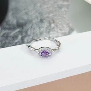 Macro view of purple oval zircon ring with halo diamonds and bamboo texture band