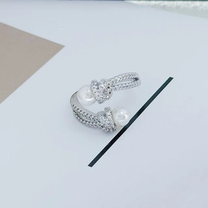 Detail view of silver open ring with pavé-set white zircons and two round pearls