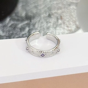 Detail of silver ring with square purple stone and embossed vertical textured edges