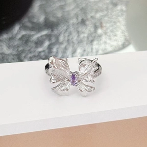 Detail of brushed silver butterfly ring featuring a purple marquise zircon and pavé diamonds