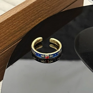 Detailansicht eines Vintage-Rings mit blauer Emaille, Sternmotiven und einem roten Edelstein