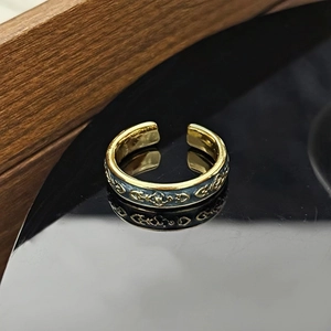 Makroansicht von Vintage Gold-Schmetterlingsring mit Relief auf schwarzer Reflexionsfläche