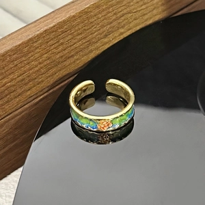 Nahaufnahme des Vintage Schmetterlingsrings mit Emaille und orangefarbenem Blütendetail