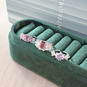 Detailed close-up of three silver-toned adjustable rings with purple crystals and pearls