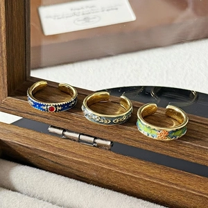 Detailansicht von Vintage-Emaille-Ringen in Königsblau und Grün mit goldener Blumenverzierung