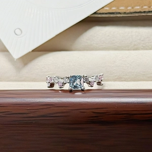 Detail of square teal gemstone ring with pink and white zircon stones on a silver band