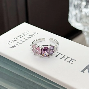 Macro detail of silver open ring with purple rectangular stone and pink zircon accents