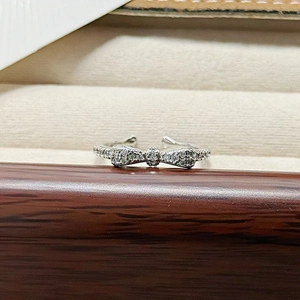 Macro detail of silver adjustable ring with butterfly bow set in full zircon pavé