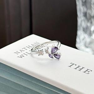 Detail of adjustable silver ring featuring purple pear-cut stones and clear crystals