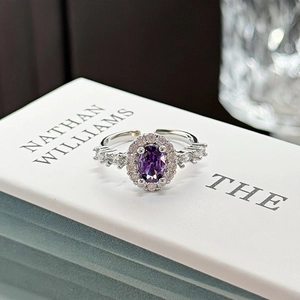 Macro detail of silver open ring with oval purple gemstone and crystal butterfly cluster