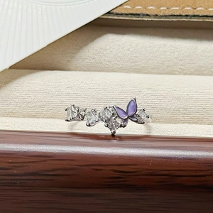 Detailed macro view of enamel butterfly and sparkling zircon on wave-shaped silver ring