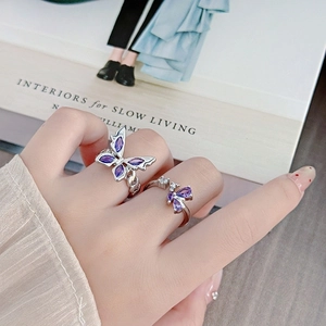 Set of two silver butterfly rings with purple stones in a stylish layered design