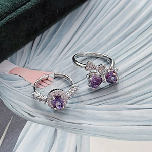 Close-up of adjustable silver rings featuring a purple butterfly and halo zircon stones