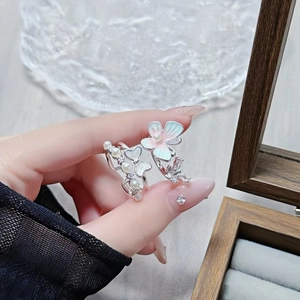 Detailed macro of enamel butterfly ring set with pearls and zircons on model hand