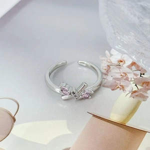 Nahaufnahme von silbernem Schleifenring mit rosa Zirkonia und Mikro-Zirkon-Einlage