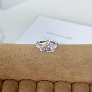 Detailansicht eines Silberrings mit Doppelschwänen und rosa herzförmigen Kristallen
